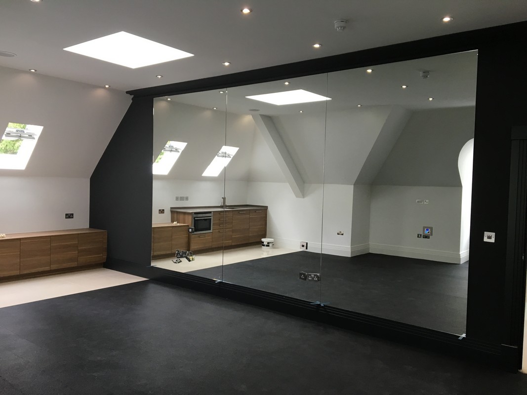 Frameless glass wall dividing loft conversion in Potters Bar